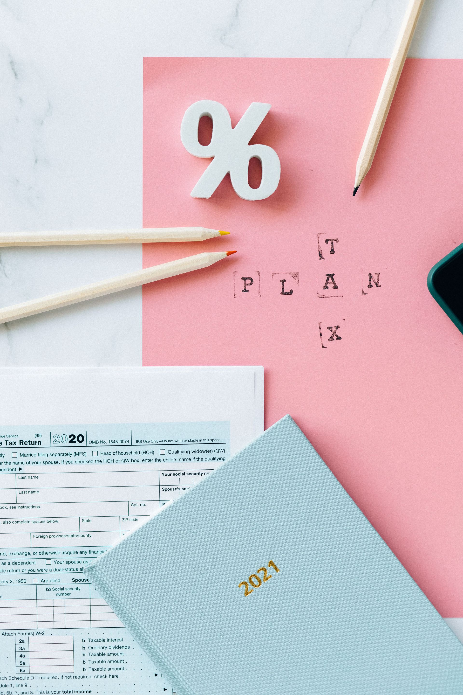 Flat lay of tax forms, calendar, and pencils illustrating tax planning.